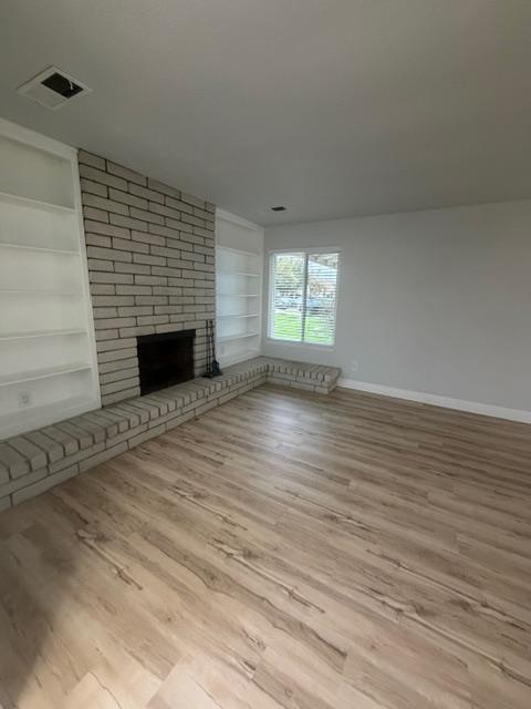 725 Sycamore Avenue Gustine, CA 95322 - Photo 4 of 31 a view of empty room with wooden floor and fireplace