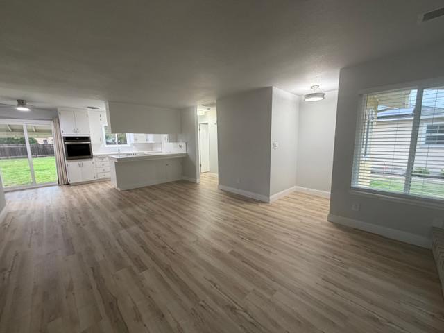 725 Sycamore Avenue Gustine, CA 95322 - Photo 9 of 31 a view of a big room with wooden floor and windows