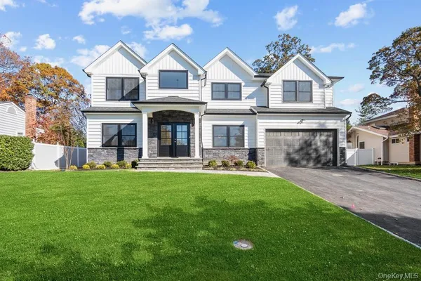 a front view of a house with yard and green space