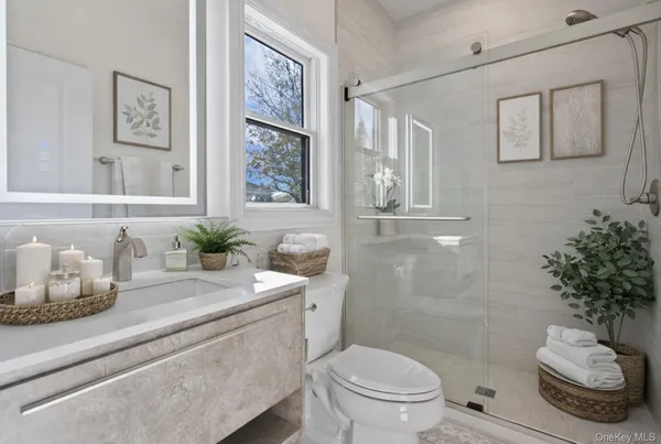 a bathroom with a granite countertop sink mirror vanity and toilet