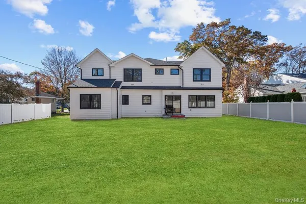 a view of a yard in front of a house with large trees