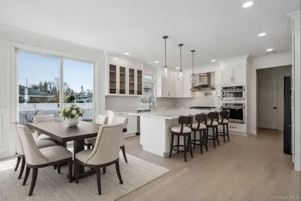 a dining area with stainless steel appliances kitchen island granite countertop a dining table chairs and view kitchen