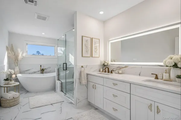 a spacious bathroom with a double vanity sink mirror and bathtub