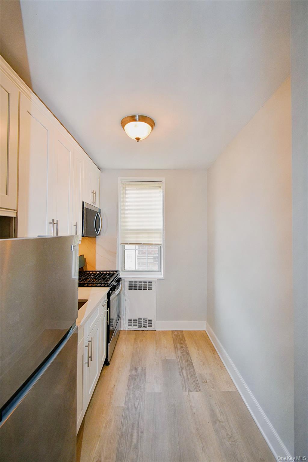 786 Bronx River Road, Unit B56 Bronxville, NY 10708 - Photo 4 of 8 a view of a kitchen with wooden floor and a sink