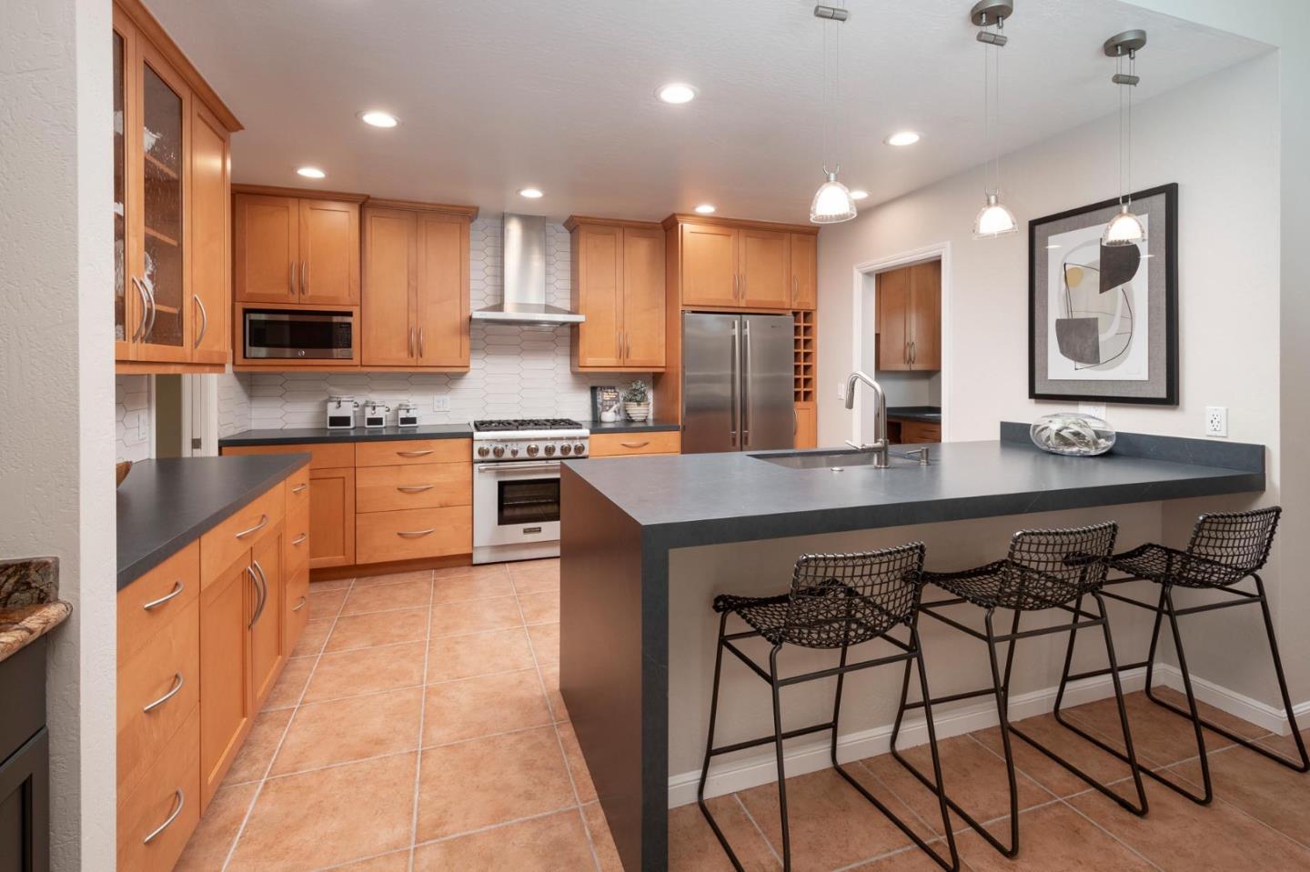 405 29th Avenue San Mateo, CA 94403 - Photo 7 of 22 a kitchen with stainless steel appliances kitchen island granite countertop a stove a sink and a refrigerator
