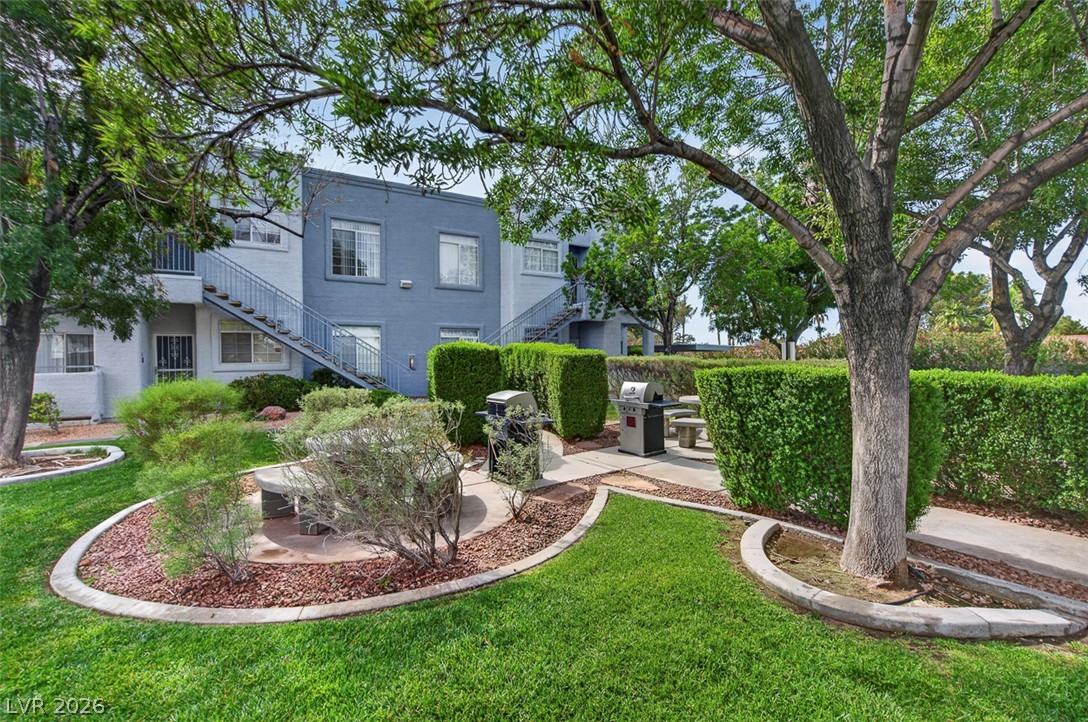 2201 Ramsgate Drive, Unit 1011 Henderson, NV 89074 - Photo 33 of 40 A verdant communal space with mature trees and grilling stations awaits outdoor gatherings.