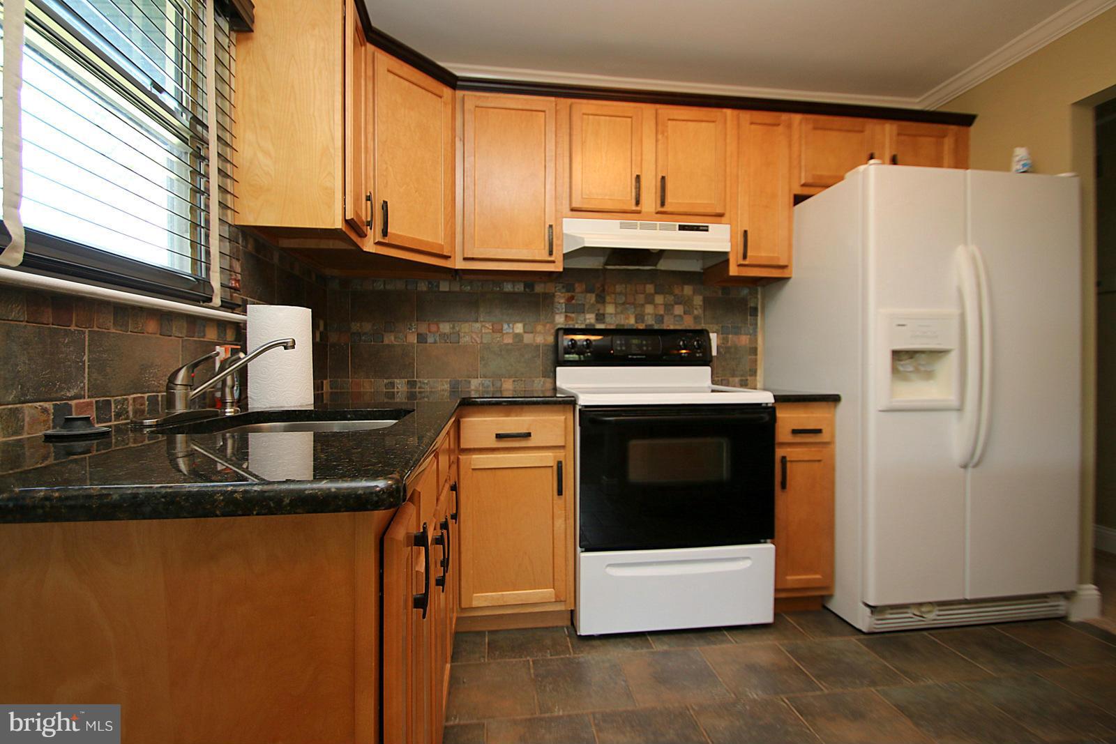 13205 Choptank Road Baltimore, MD 21220 - Photo 14 of 30 a kitchen with a sink a stove and refrigerator