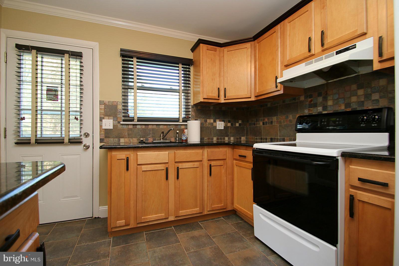13205 Choptank Road Baltimore, MD 21220 - Photo 15 of 30 a kitchen with stainless steel appliances granite countertop a stove a sink and a microwave