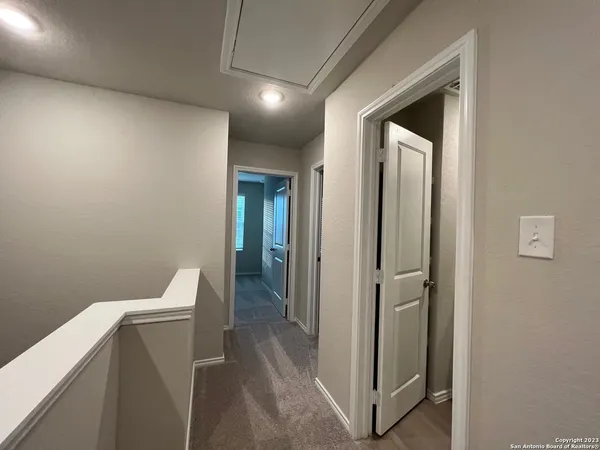 a view of a hallway with toilet and a hallway