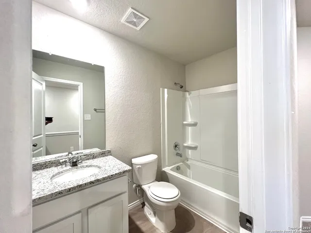 a bathroom with a granite countertop sink toilet and shower