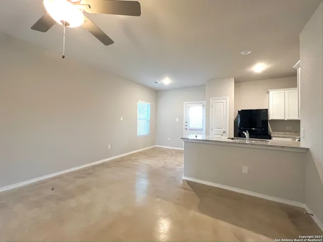 a view of kitchen with stainless steel appliances granite countertop a refrigerator a oven a sink with a dining table and chairs