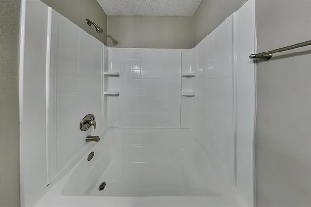 a bathroom with a shower and a bath tub
