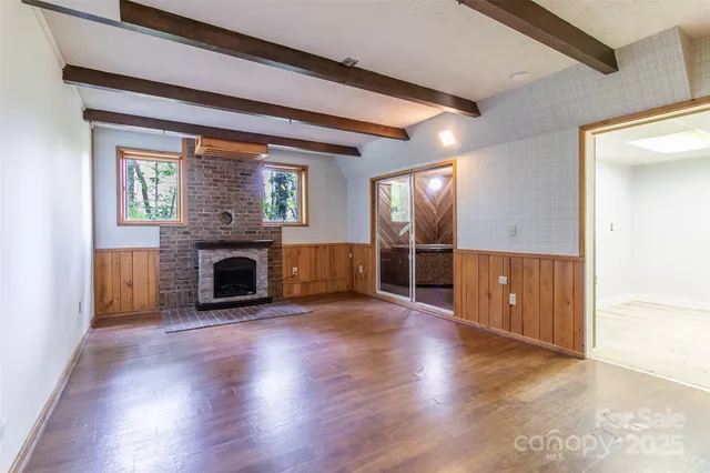 a view of a livingroom with a fireplace wooden floor and window