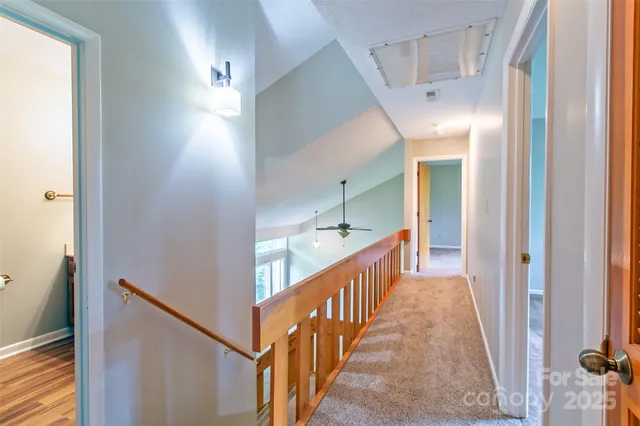 a view of a hallway with wooden floor and staircase
