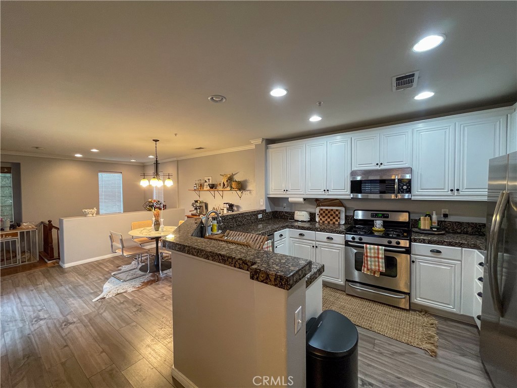 33570 Emerson Way, Unit C Temecula, CA 92592 - Photo 18 of 52 a kitchen with a sink stove and wooden cabinets