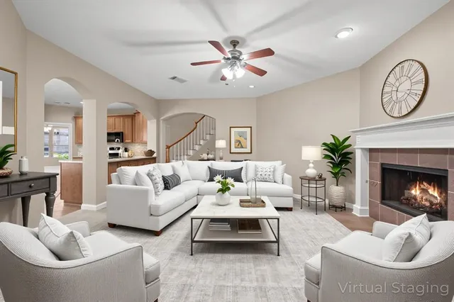 a living room with furniture a fireplace and a large mirror