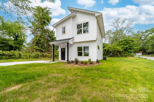 a front view of a house with a yard and trees