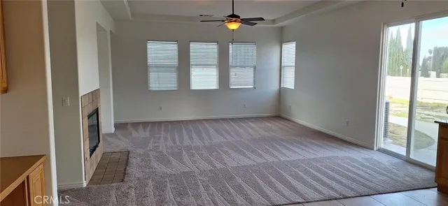 an empty room with wooden floor staircase and windows