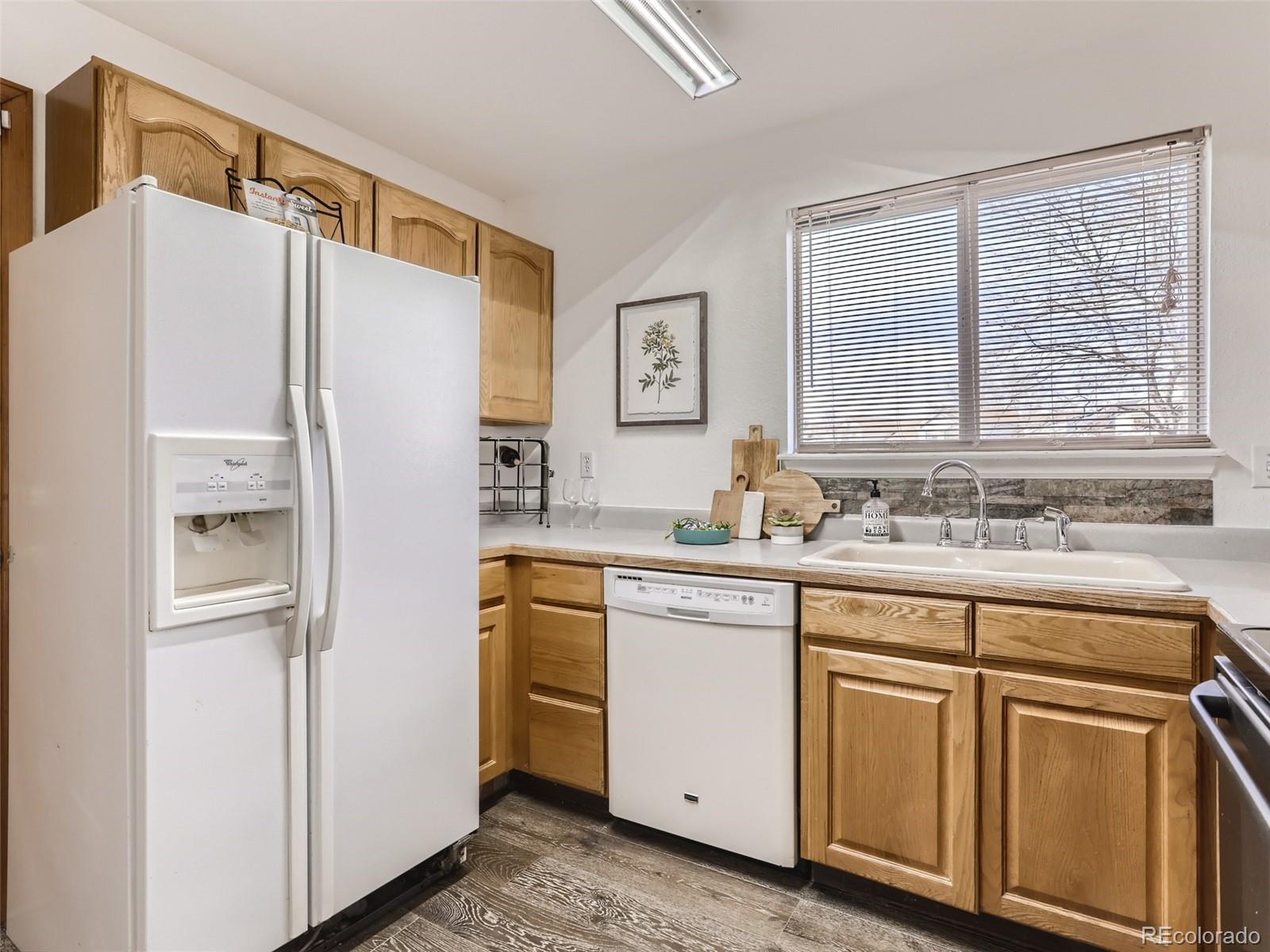 4399 Perth Circle Denver, CO 80249 - Photo 12 of 30 a kitchen with white cabinets and white refrigerator