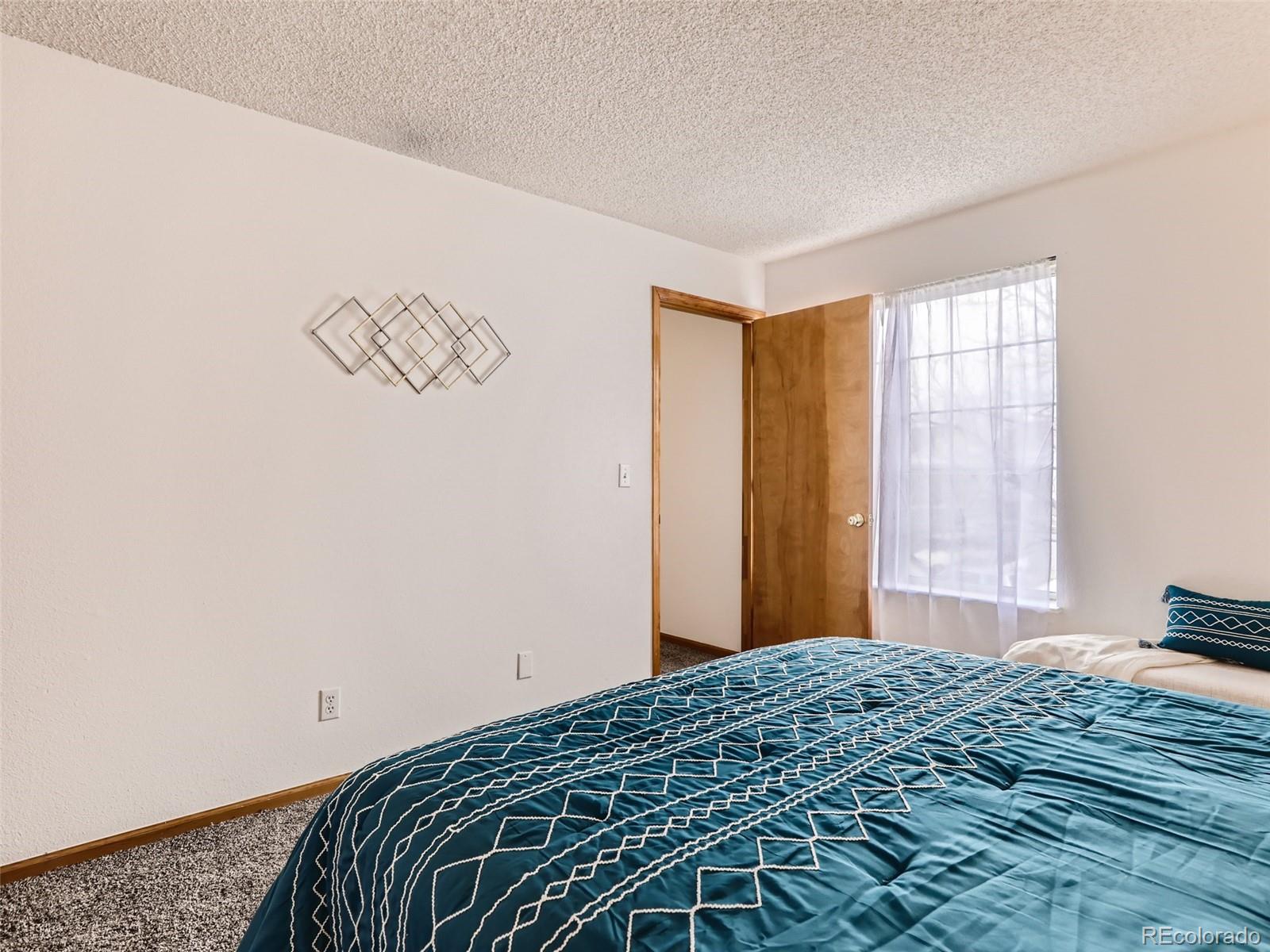 4399 Perth Circle Denver, CO 80249 - Photo 17 of 30 a bedroom with a bed and a window