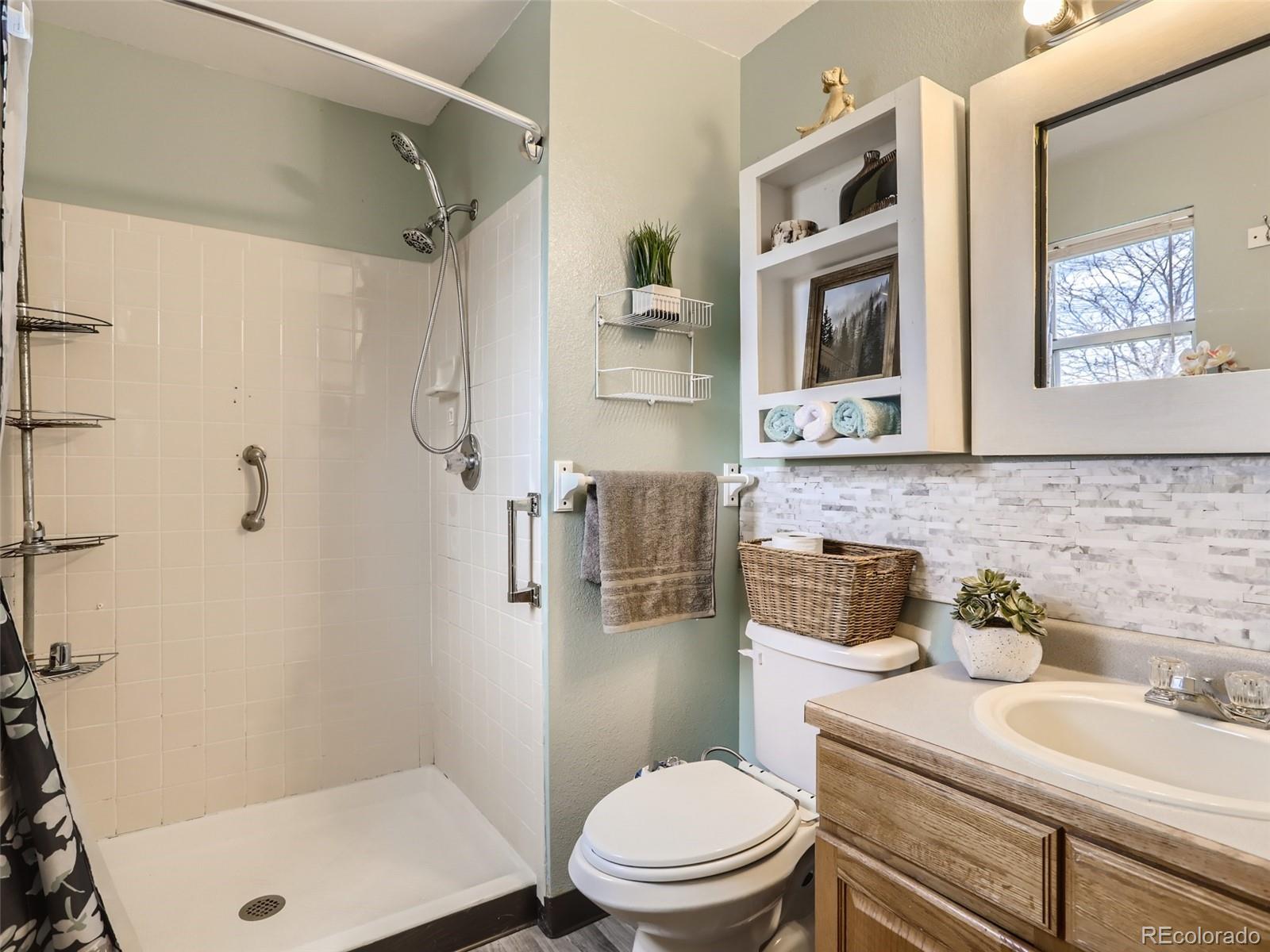 4399 Perth Circle Denver, CO 80249 - Photo 19 of 30 a bathroom with a granite countertop toilet sink and shower