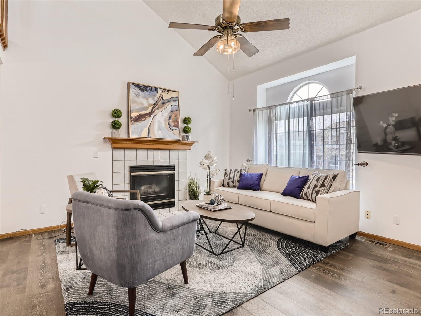 4399 Perth Circle Denver, CO 80249 - Photo 6 of 30 a living room with furniture a flat screen tv and a fireplace