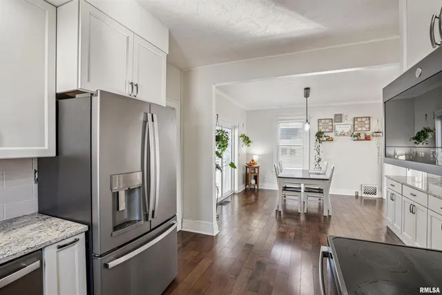 a kitchen with stainless steel appliances a refrigerator and wooden floor