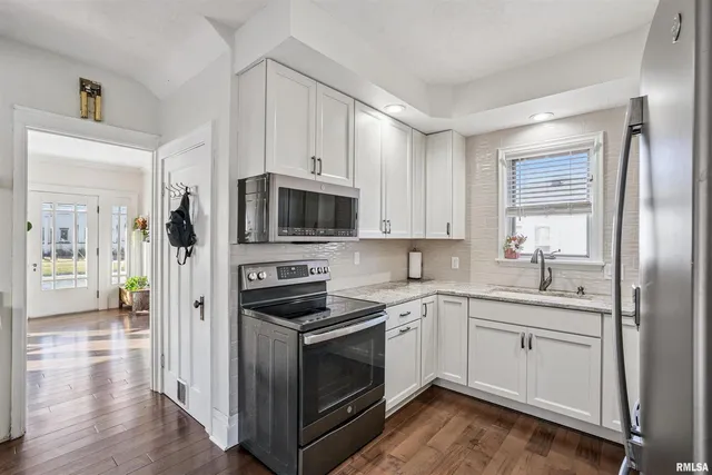 a kitchen with stainless steel appliances a white stove top oven and sink