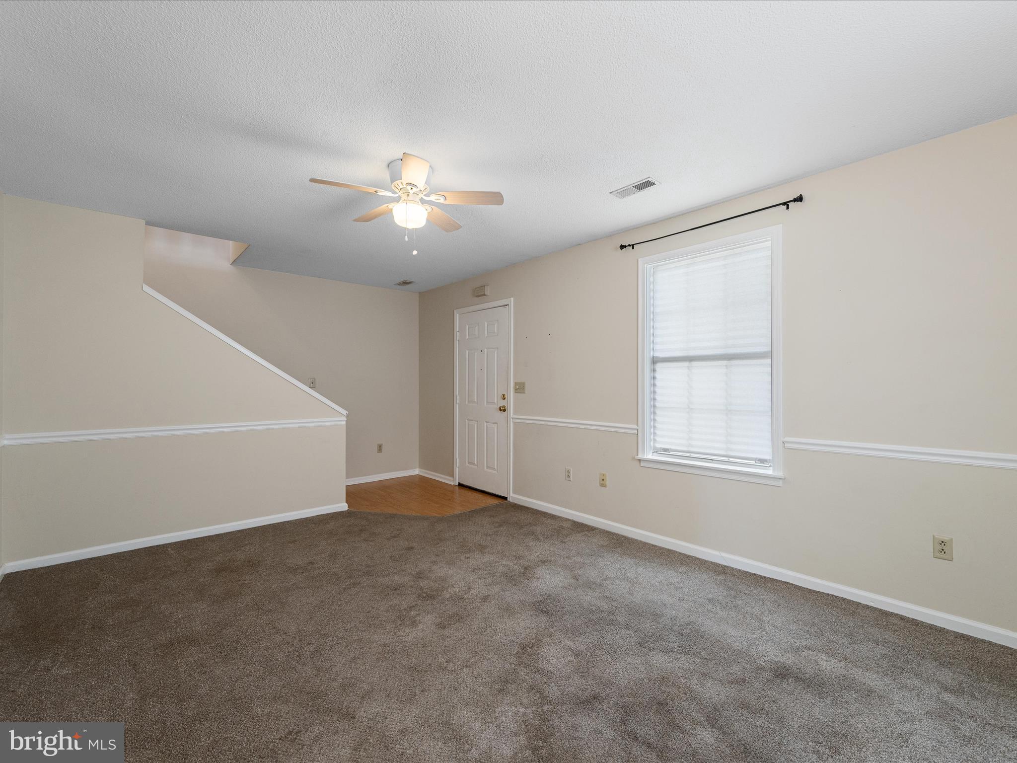 208 South Marshall Street Ranson, WV 25438 - Photo 4 of 28 an empty room with chandelier fan and windows