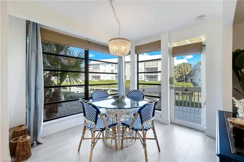 a dining room with furniture a chandelier and wooden floor