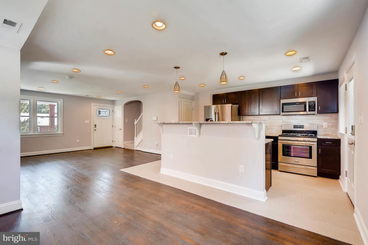 3834 Rexmere Road Baltimore, MD 21218 - Photo 13 of 28 a kitchen with stainless steel appliances granite countertop a refrigerator oven a sink dishwasher and white cabinets with wooden floor