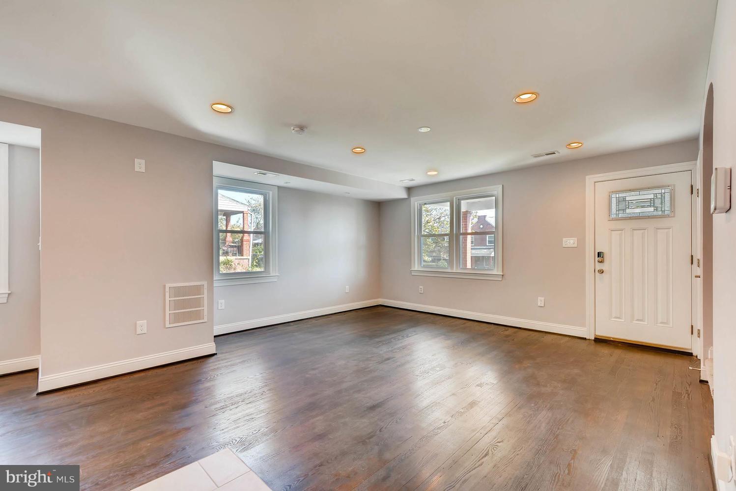 3834 Rexmere Road Baltimore, MD 21218 - Photo 6 of 28 an empty room with wooden floor and windows