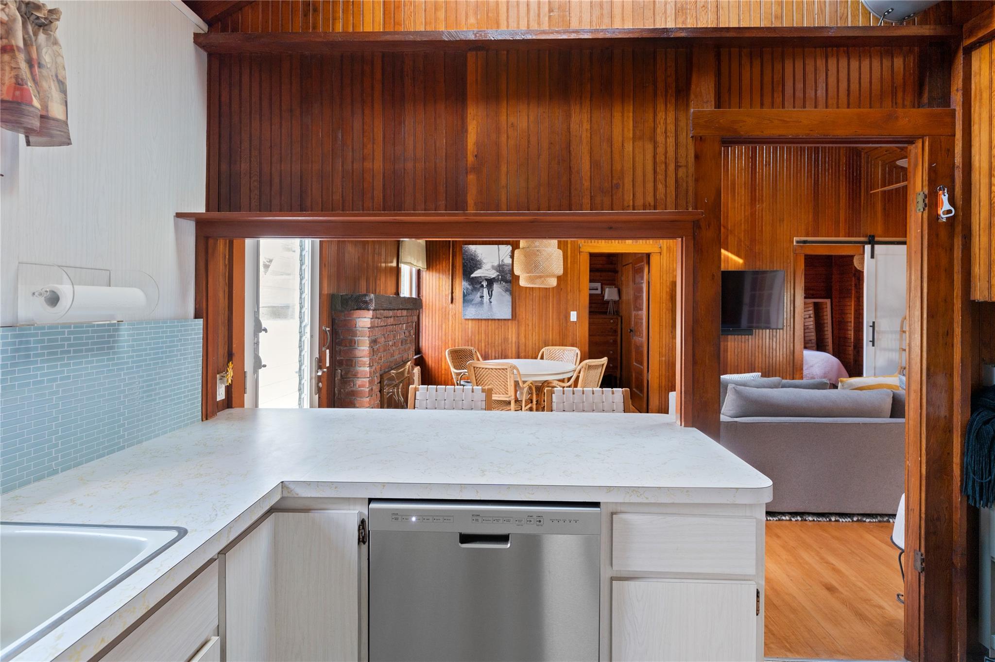 760 Surf Road Ocean Beach, NY 11770 - Photo 11 of 16 Kitchen with wooden walls, a barn door, dishwasher, and sink