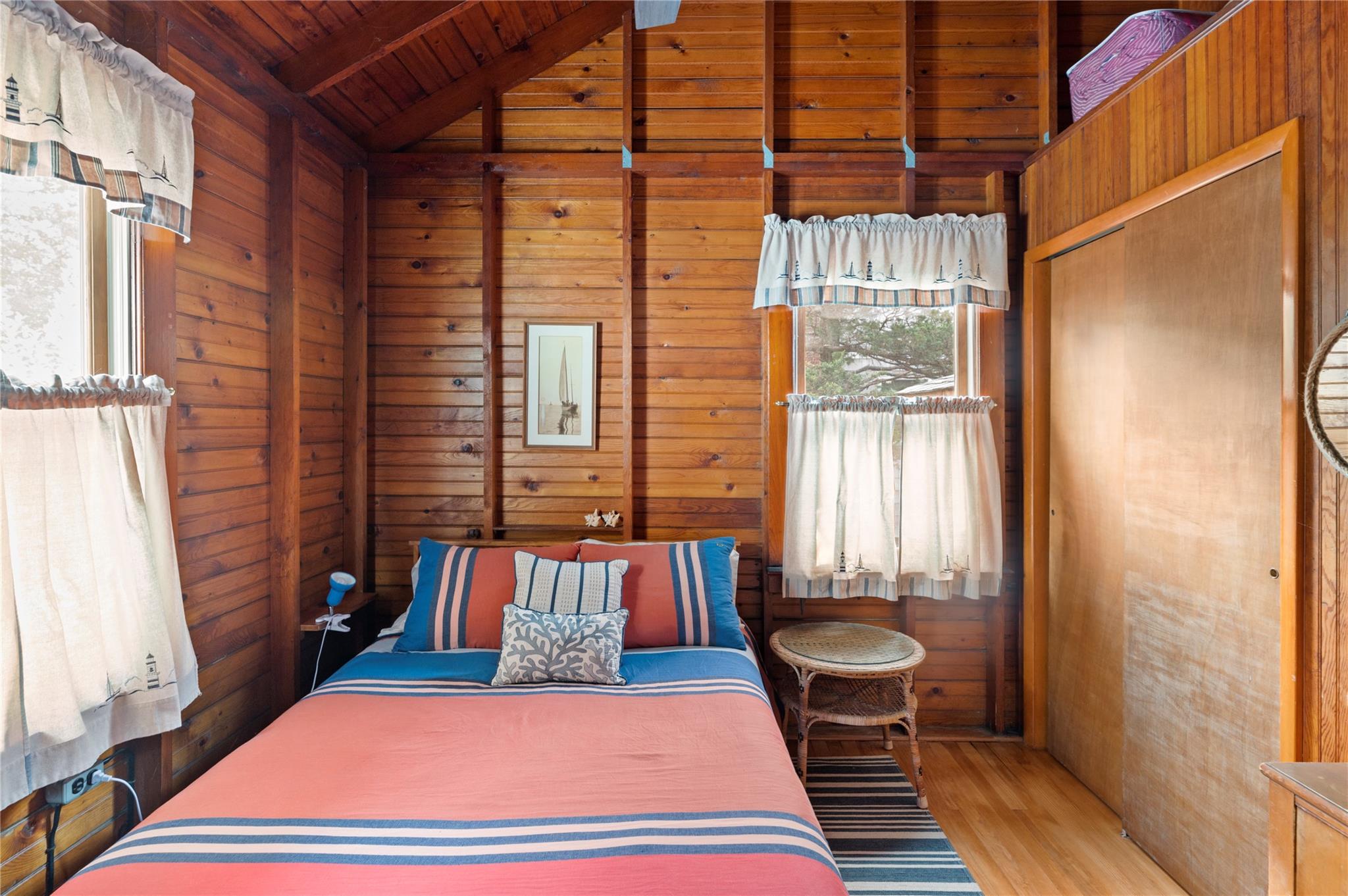 760 Surf Road Ocean Beach, NY 11770 - Photo 9 of 16 Bedroom with vaulted ceiling with beams, wooden ceiling, wooden walls, and light hardwood / wood-style flooring