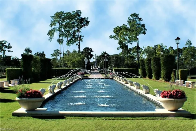 a view of a swimming pool with a yard and trees in the background