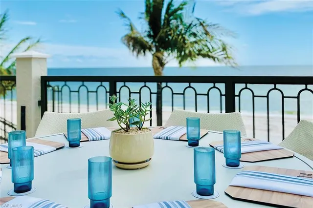 a roof deck with table and chairs under an umbrella