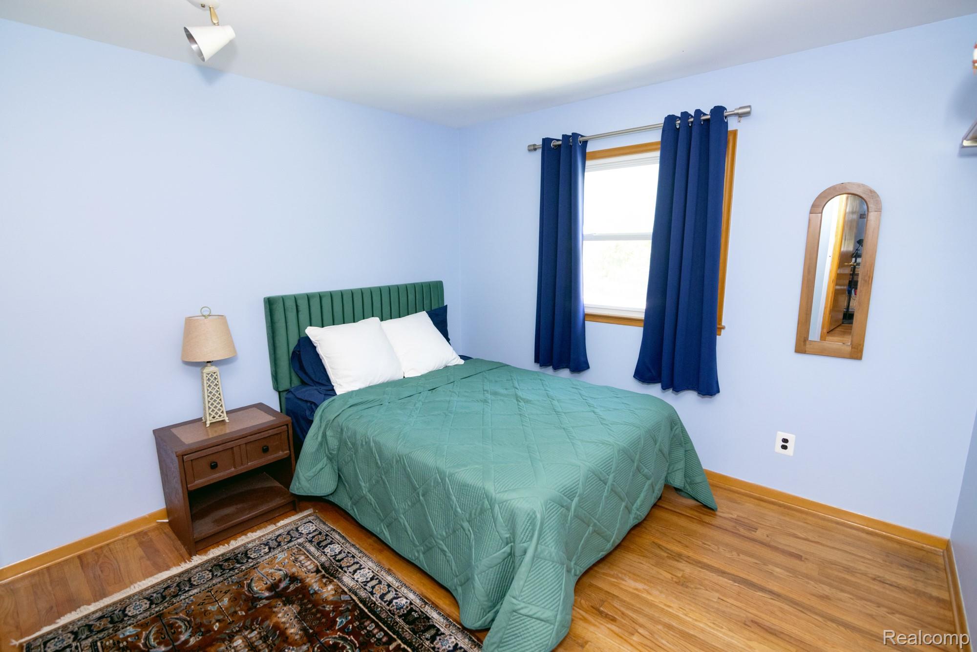 724 Sandstone Drive Rochester, MI 48309 - Photo 11 of 60 Bedroom featuring wood-finish flooring and light blue walls