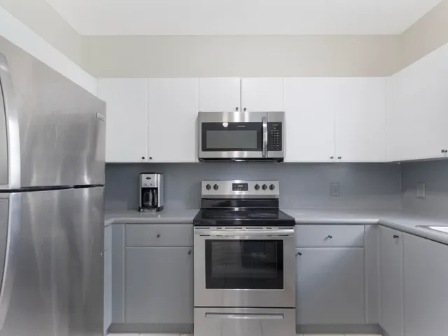 a kitchen with stainless steel appliances a refrigerator stove and microwave