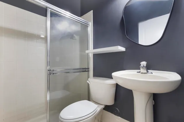 a bathroom with a sink toilet and mirror