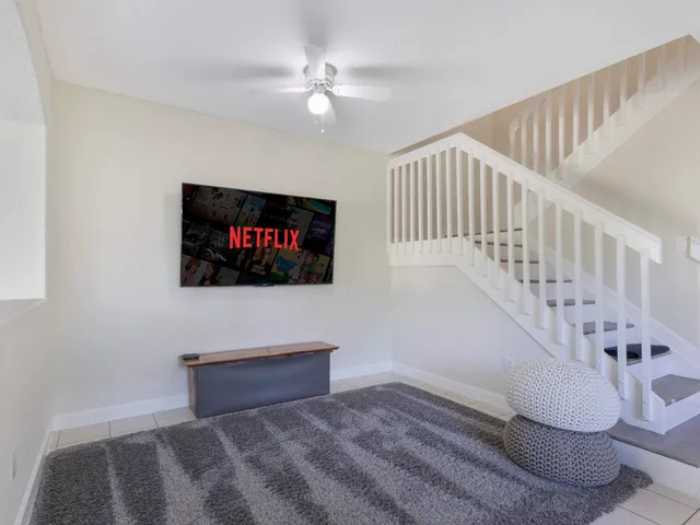 a living room with wooden floor and a flat screen tv
