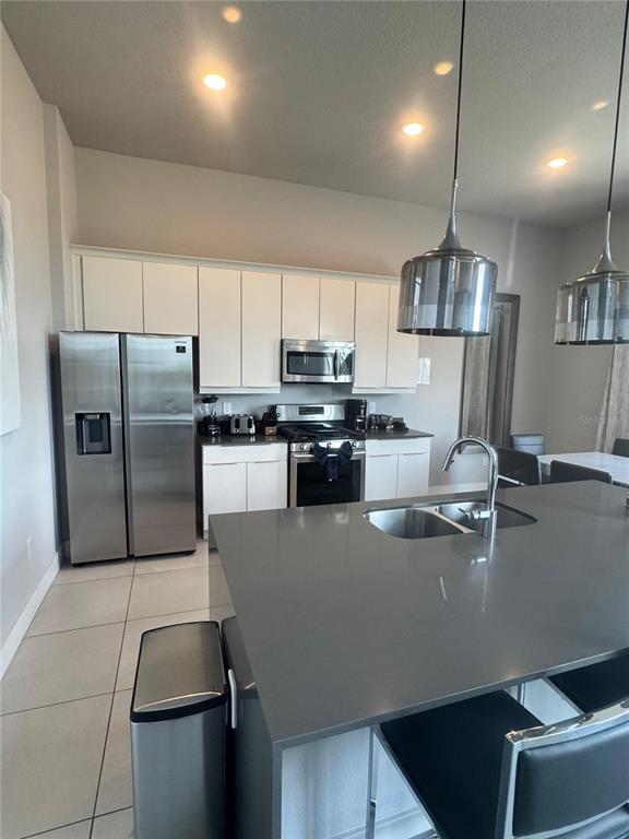 7770 Sandy Ridge Drive, Unit 210 Reunion, FL 34747 - Photo 37 of 42 a kitchen with stainless steel appliances granite countertop a refrigerator a sink a stove and a refrigerator