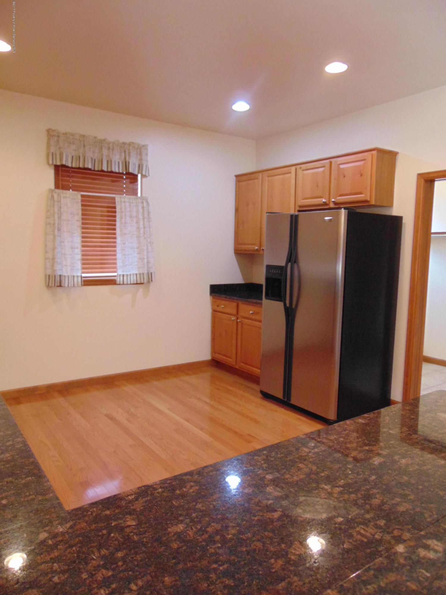 1193 East 19th Street Rifle, CO 81650 - Photo 13 of 40 a view of an empty room with wooden floor and a kitchen