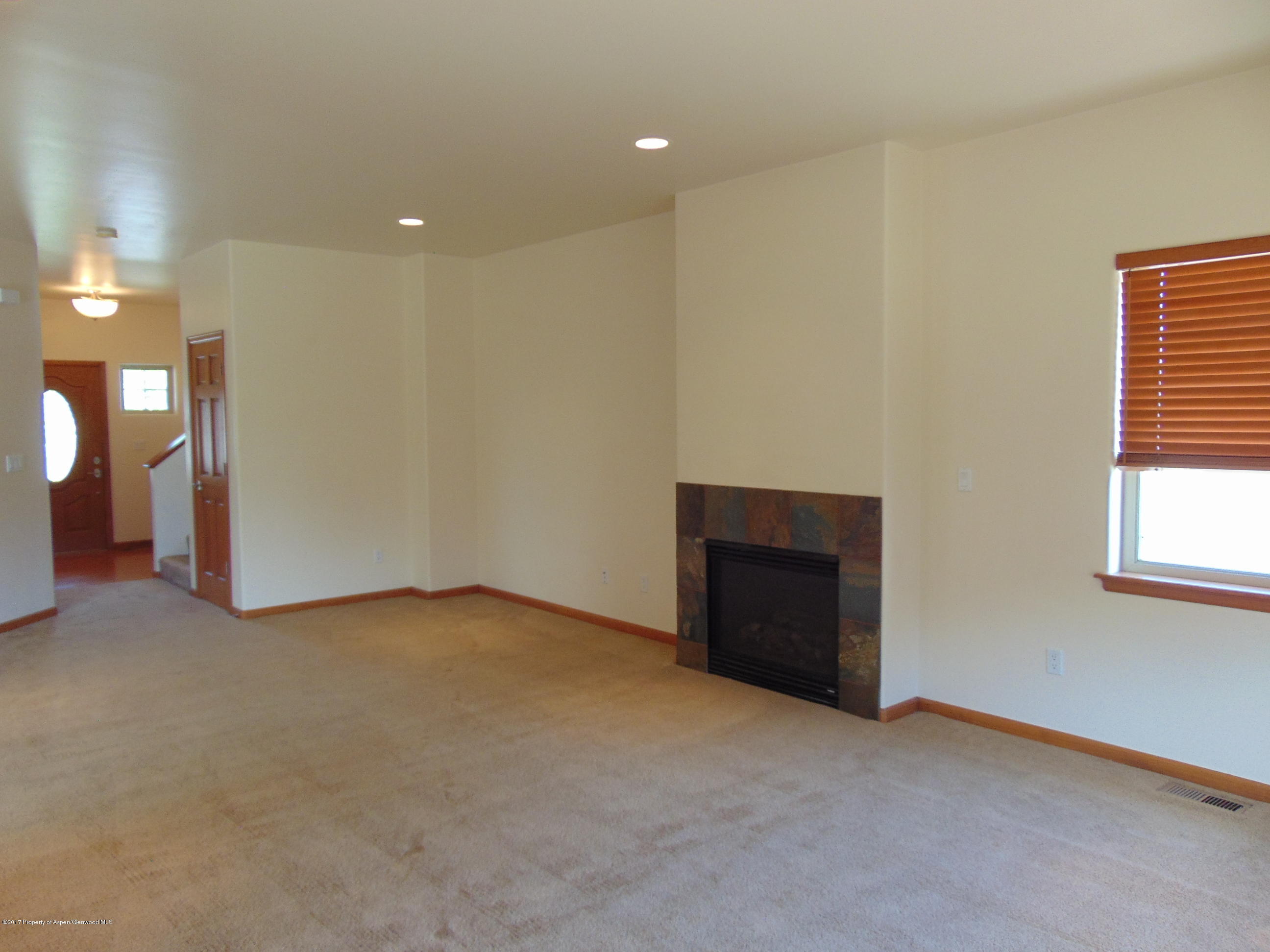 1193 East 19th Street Rifle, CO 81650 - Photo 9 of 40 an empty room with a fireplace and window