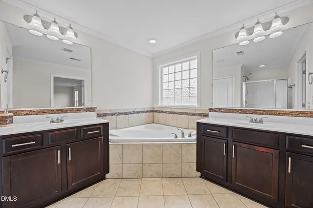 a spacious bathroom with a granite countertop sink a mirror a bathtub and window