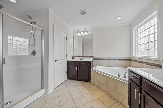 a large white bathroom with a granite countertop sink a bathtub and shower