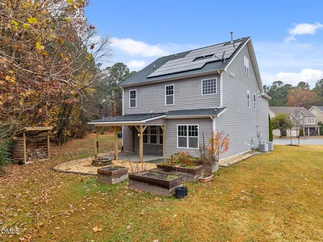 a backyard of a house with yard table and chairs