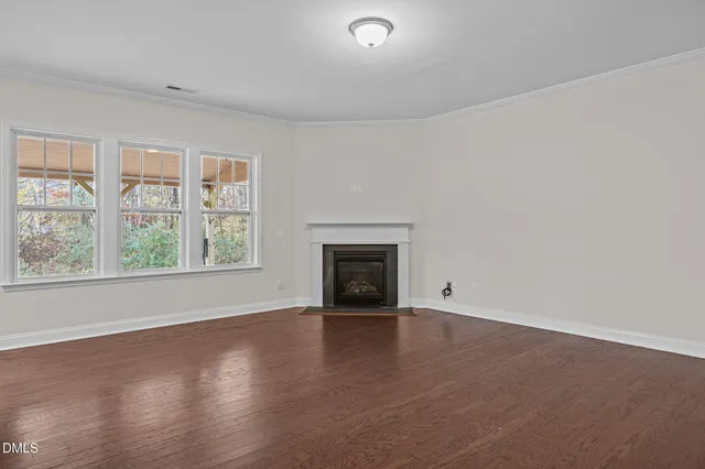 wooden floor fireplace and windows in an empty room