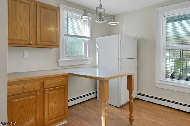 a kitchen with granite countertop wooden cabinets a dining table and chairs
