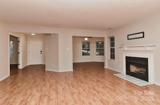 a view of a livingroom with wooden floor and a fireplace