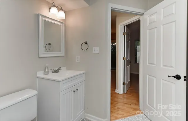 a bathroom with a toilet sink vanity and mirror